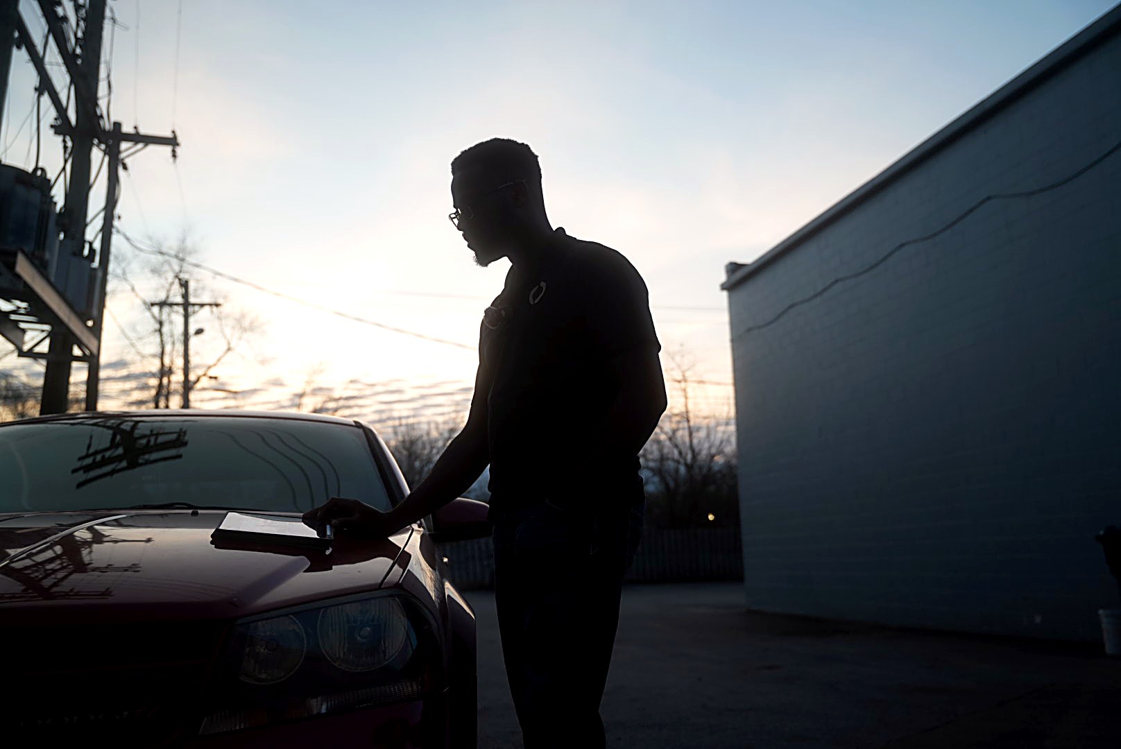 Anthony Walker Jr. standing beside a car at sunset